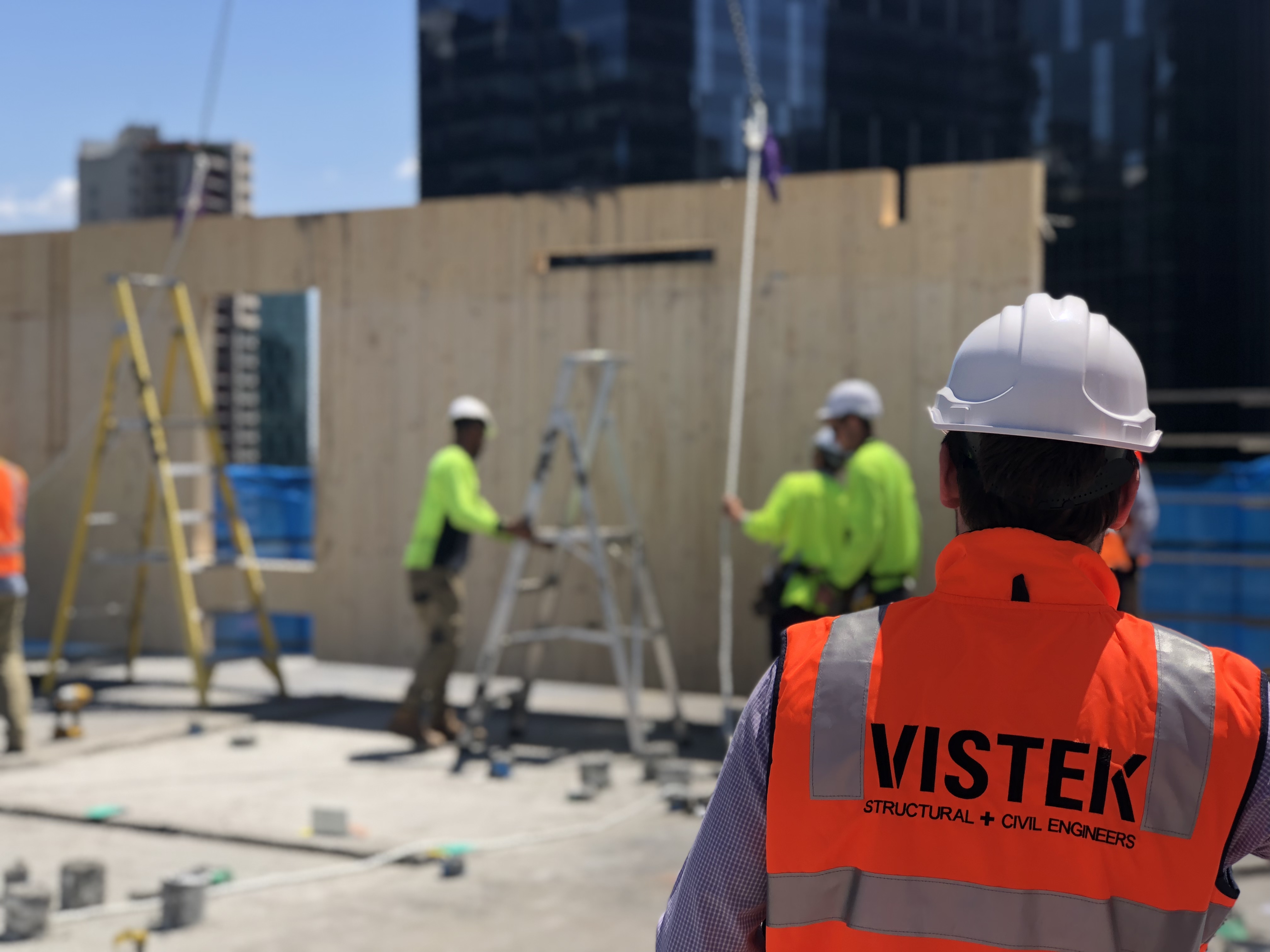 Vistek engineer on site observing a CLT panel being placed by crane
