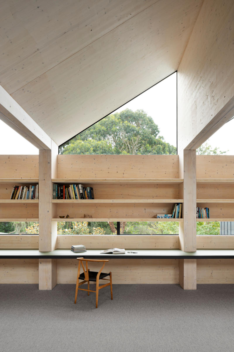 Chair and built-in desk with view onto native bushland, sawtooth CLT roof